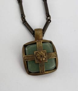 Bronze pendant with green stone centerpiece.