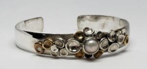 Silver bracelet with decorative pearl accents.