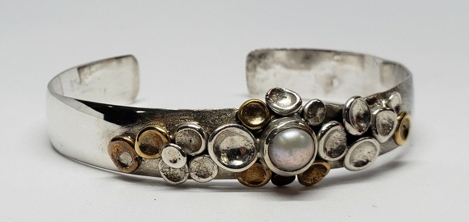 Silver bracelet with decorative pearl accents.