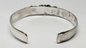 Silver cuff bracelet on white background.
