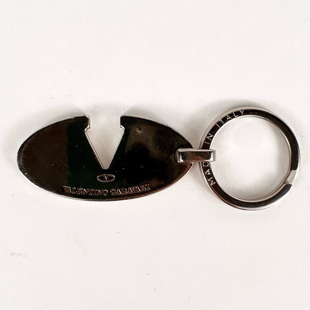 Metal keychain featuring an oval design.