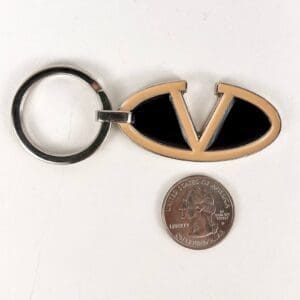 Keychain with "V" emblem beside coin.