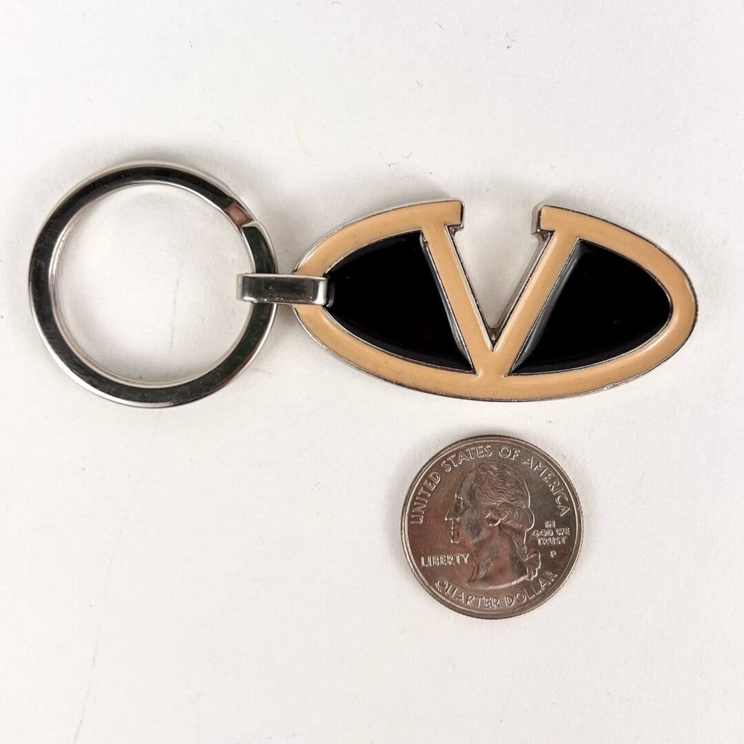 Keychain with "V" emblem beside coin.