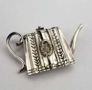 Ornate silver teapot with intricate design.