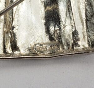Close-up of a silver object with hallmark.