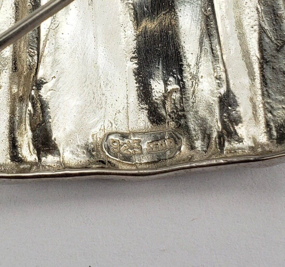 Close-up of a silver object with hallmark.