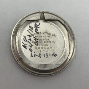 Watch back cover with handwritten notes.