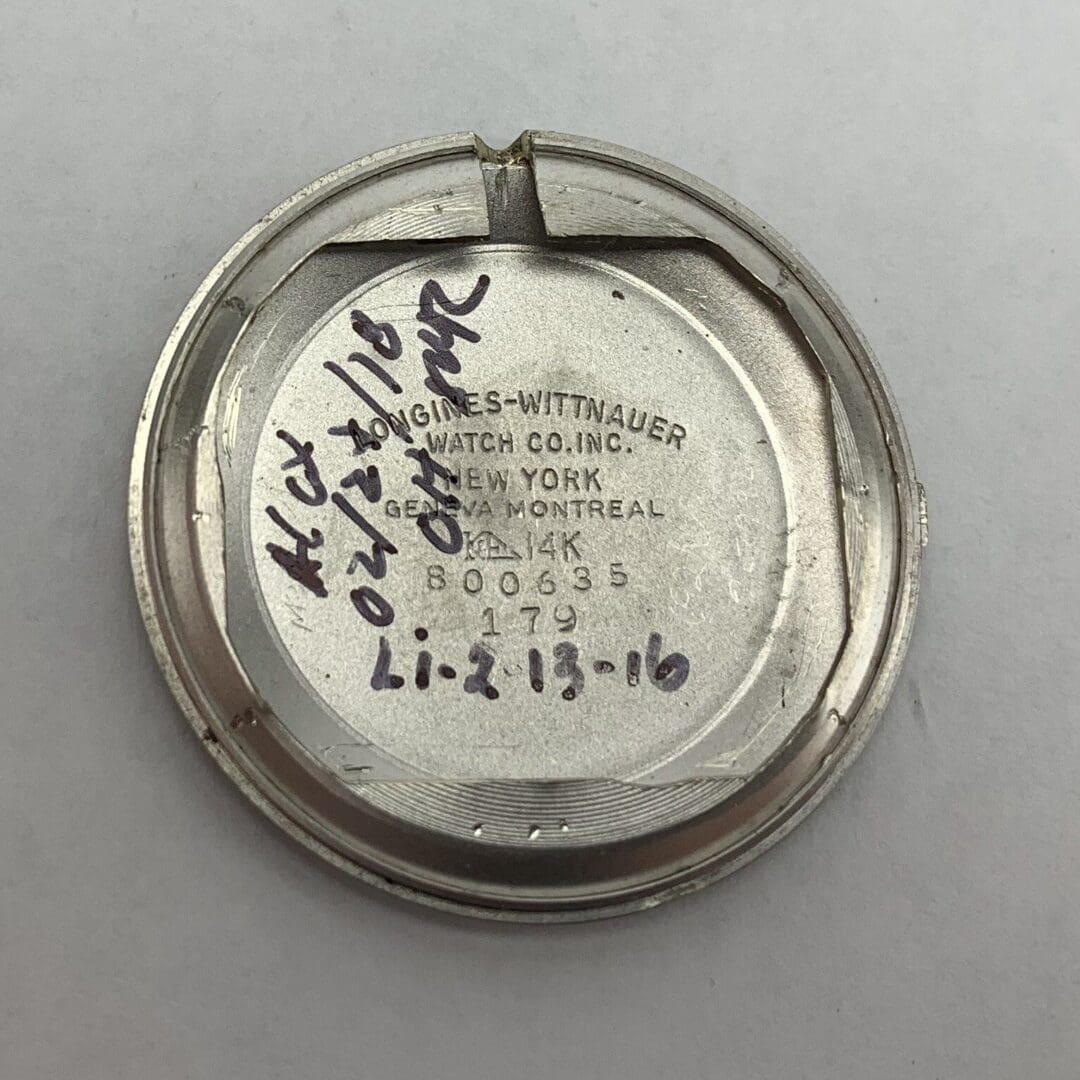 Watch back cover with handwritten notes.