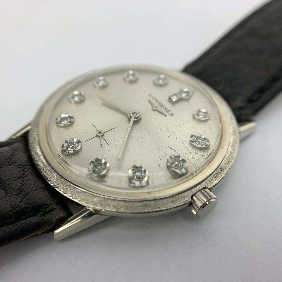 Silver watch with black leather strap.