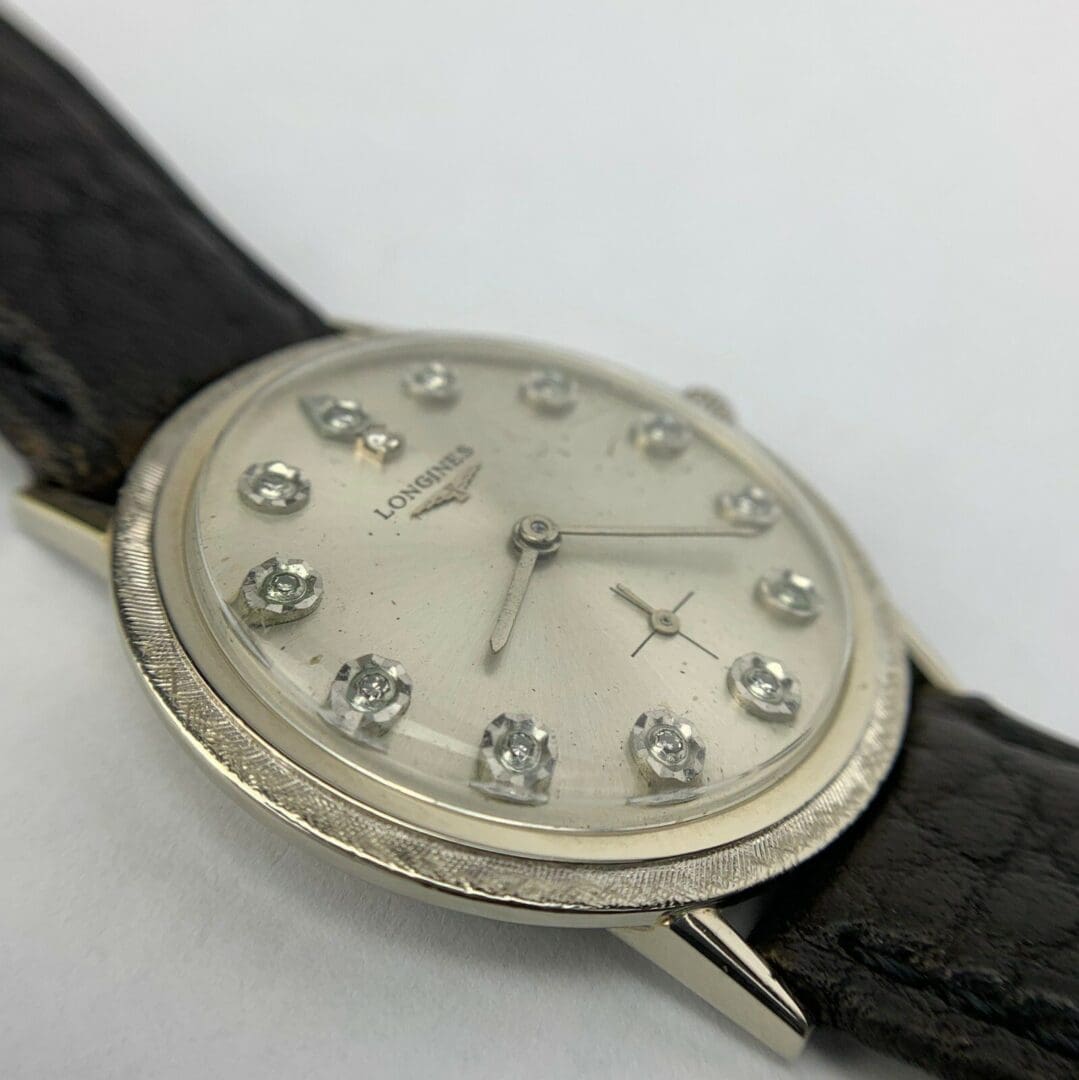 Silver watch with black leather strap.