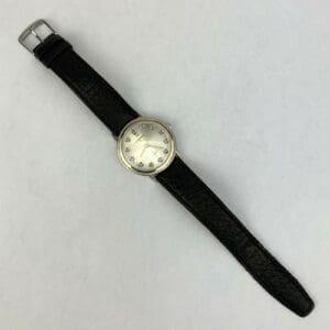 Silver watch with black leather strap.