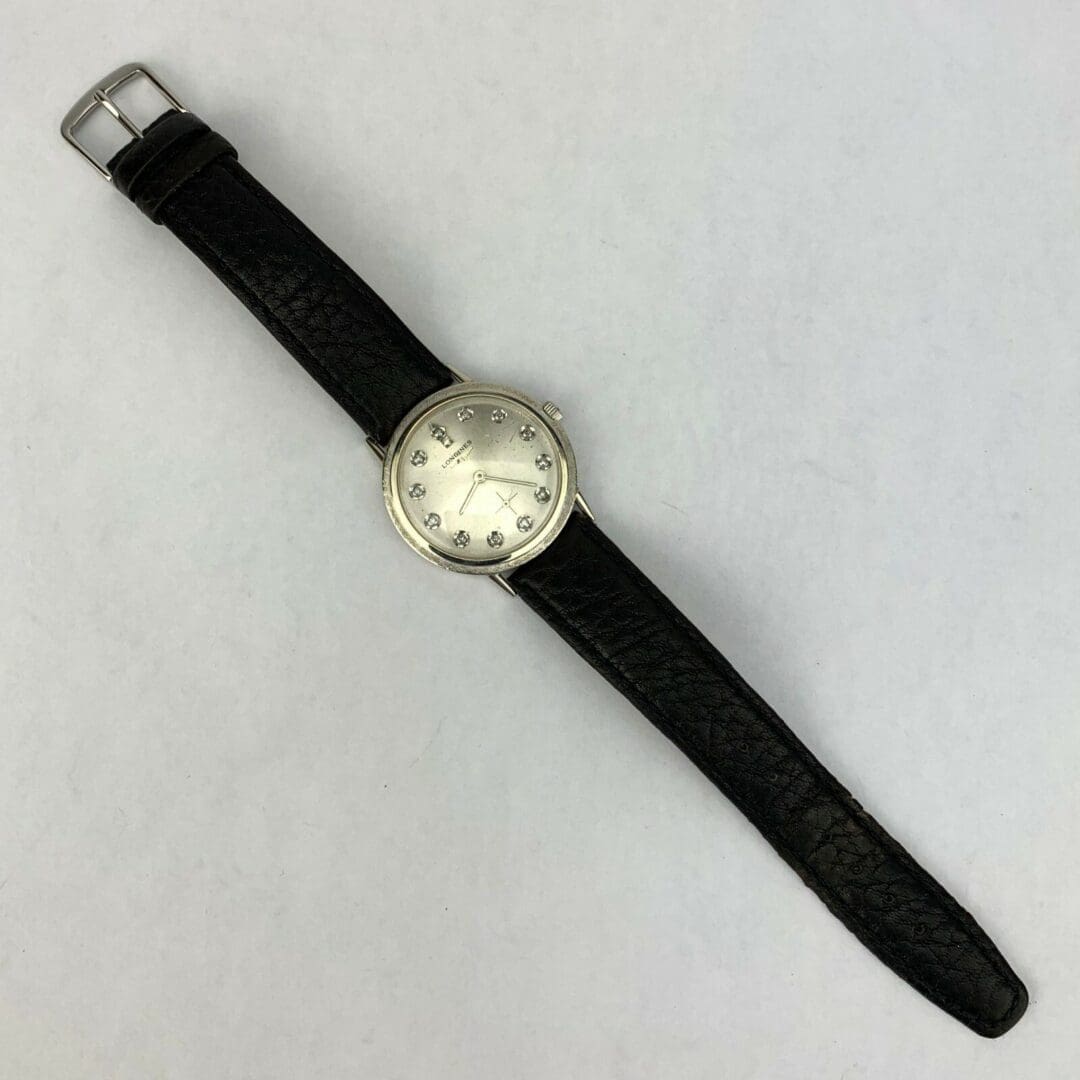 Silver watch with black leather strap.