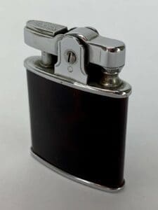 Vintage metal and black pocket lighter.