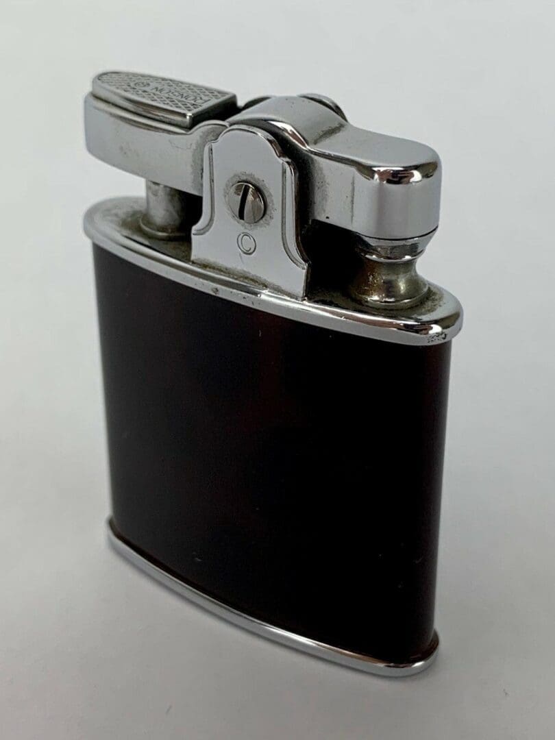 Vintage metal and black pocket lighter.