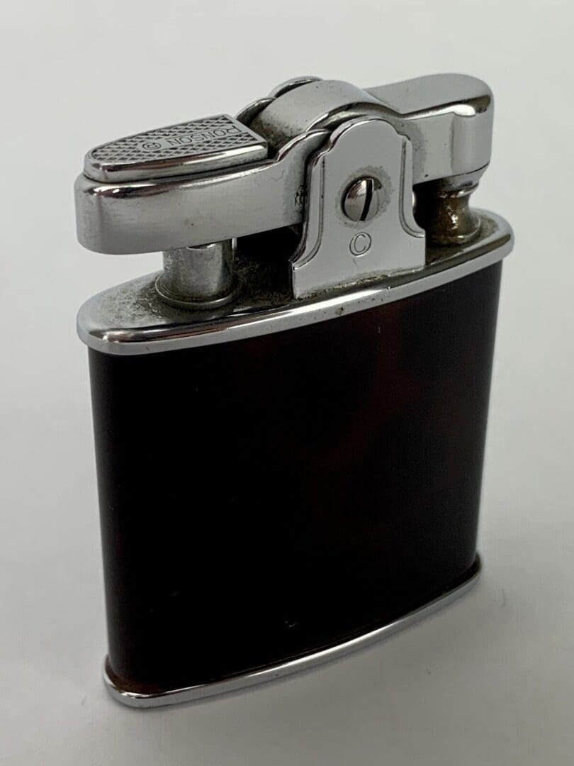 Vintage metal and black cigarette lighter.
