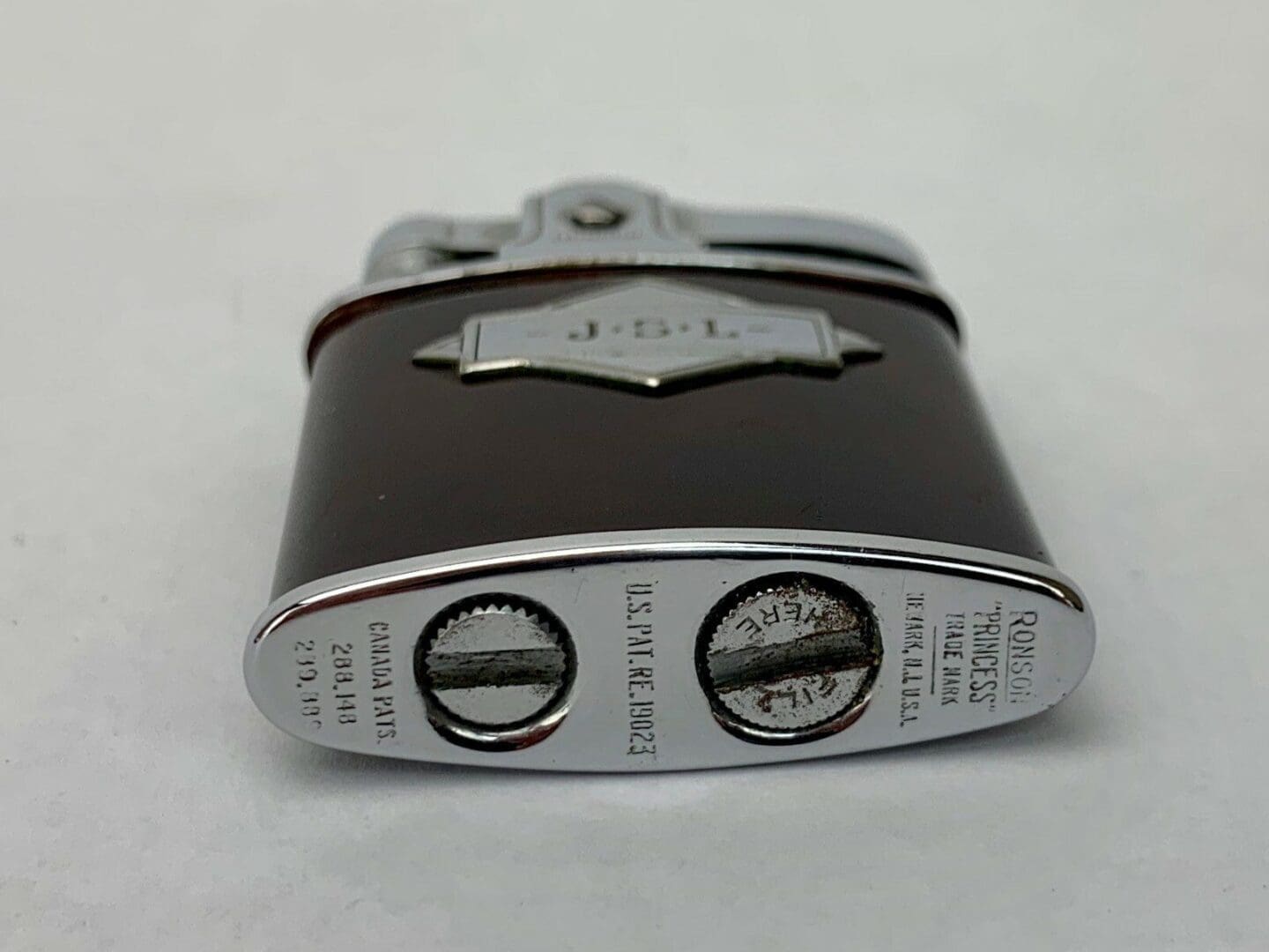Vintage metal lighter with engraved details.
