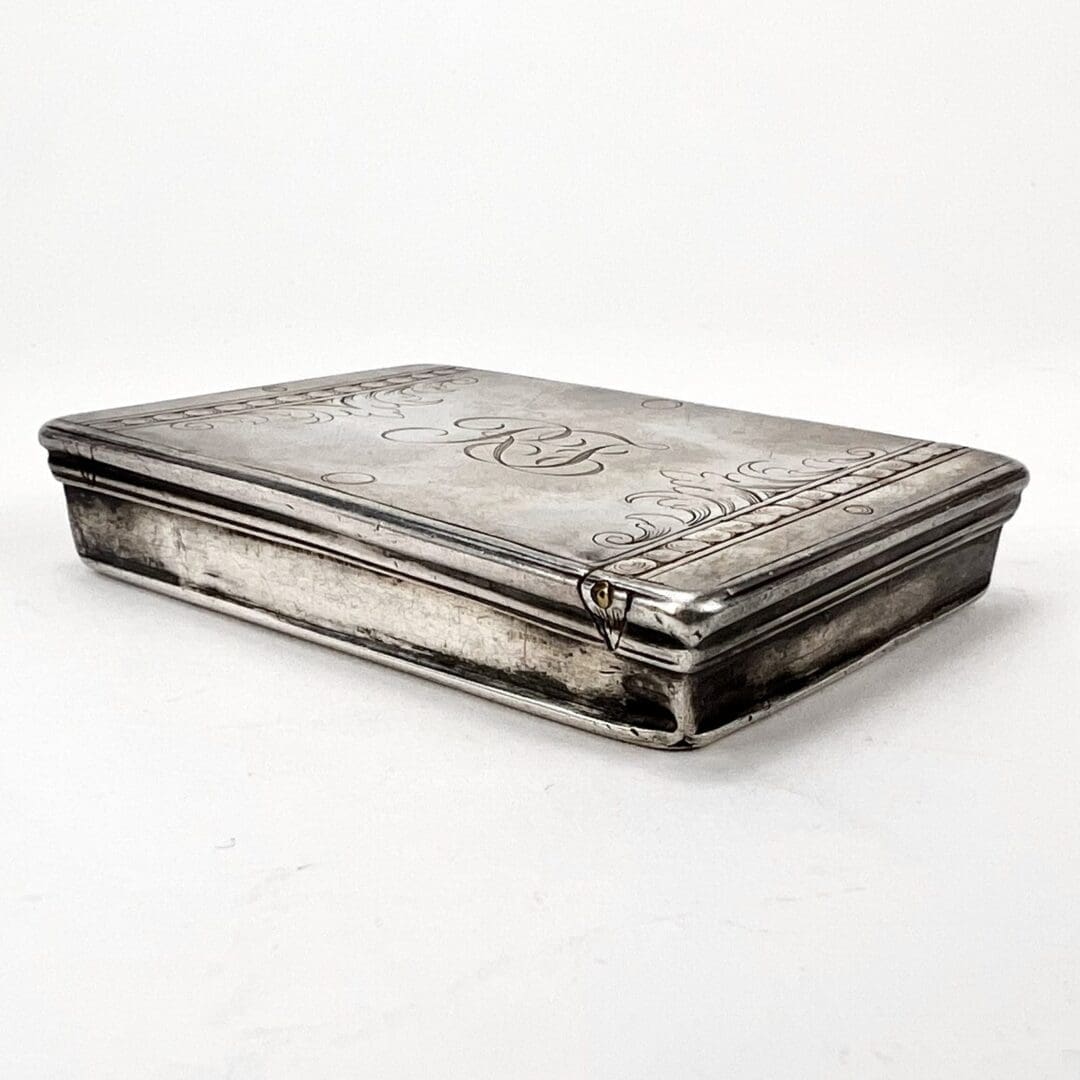 Engraved silver box with intricate details.