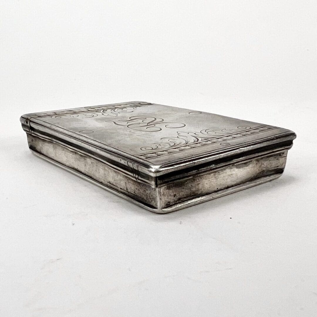 Silver rectangular box with engraved designs.