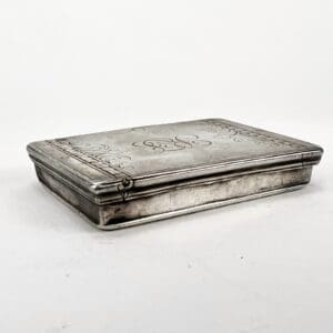 Engraved silver box with decorative patterns.