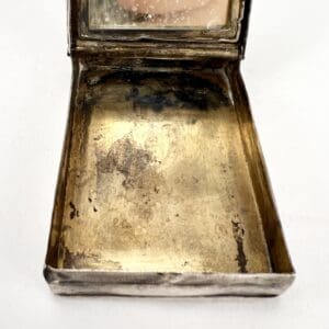 Open vintage metal compact with mirror.