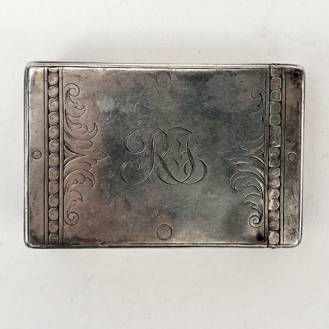 Engraved silver box with decorative patterns.