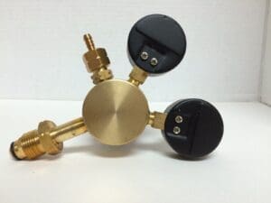 Brass gas pressure regulator with two gauges.