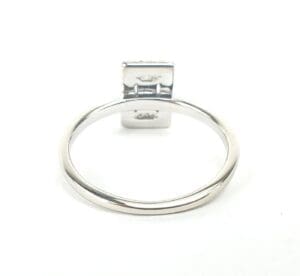 Silver ring with square setting on top.
