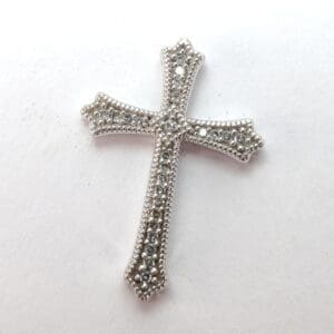 Silver cross with intricate beaded design.