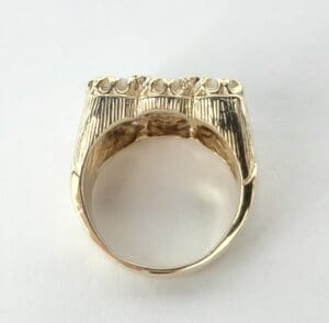 Gold ring with intricate engraved design.