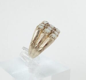 Gold ring with white gemstones displayed upright.