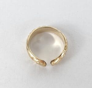 Gold open ring on white background.