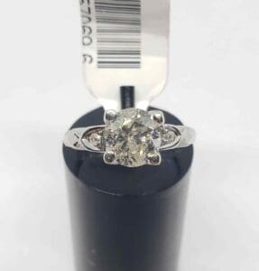 Diamond ring on a black cylindrical stand.