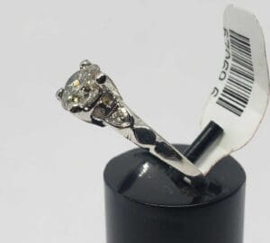 Diamond ring on a black stand.