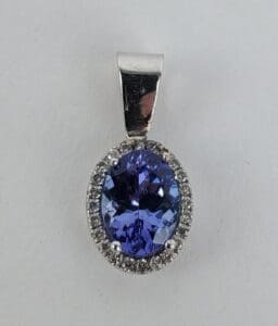 Oval blue gemstone pendant with diamonds.