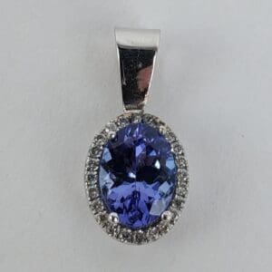 Oval blue gemstone pendant with diamonds.