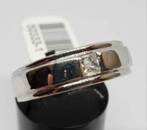 Silver ring with a square diamond.