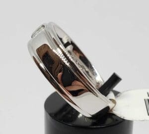 Silver ring on a black display stand.