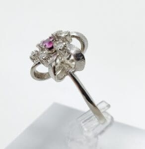 Silver ring with pink gemstone, intricate design.