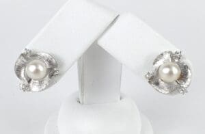 Silver earrings with pearls and diamond accents.