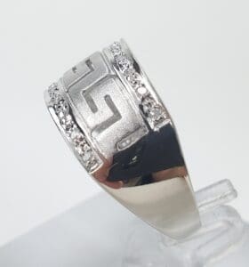 Silver ring with geometric pattern and diamonds.