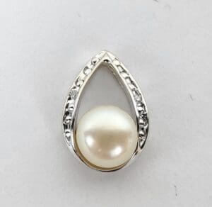 Teardrop-shaped pendant with pearl and diamonds.