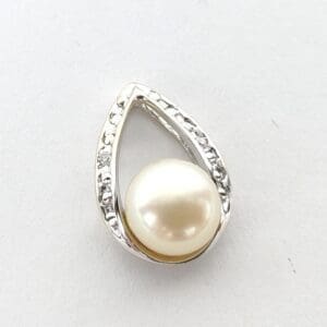 Teardrop-shaped pendant with pearl and diamonds.