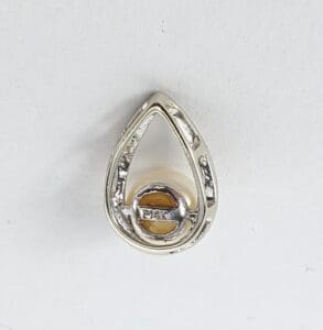 Teardrop-shaped silver pendant with pearl.