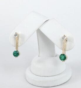Gold earrings with green and clear stones.