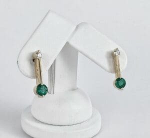 Gold earrings with green and clear stones.