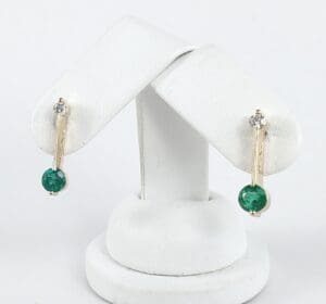 Gold earrings with green and clear stones.