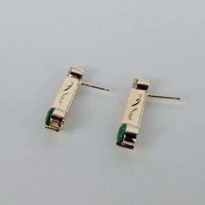 Gold earrings with green stone accents.