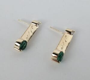Gold earrings with green gemstone accents.