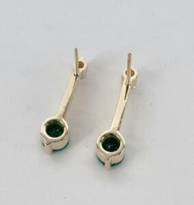 Gold earrings with green gemstone accents.