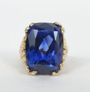 Blue gemstone ring with ornate gold setting.
